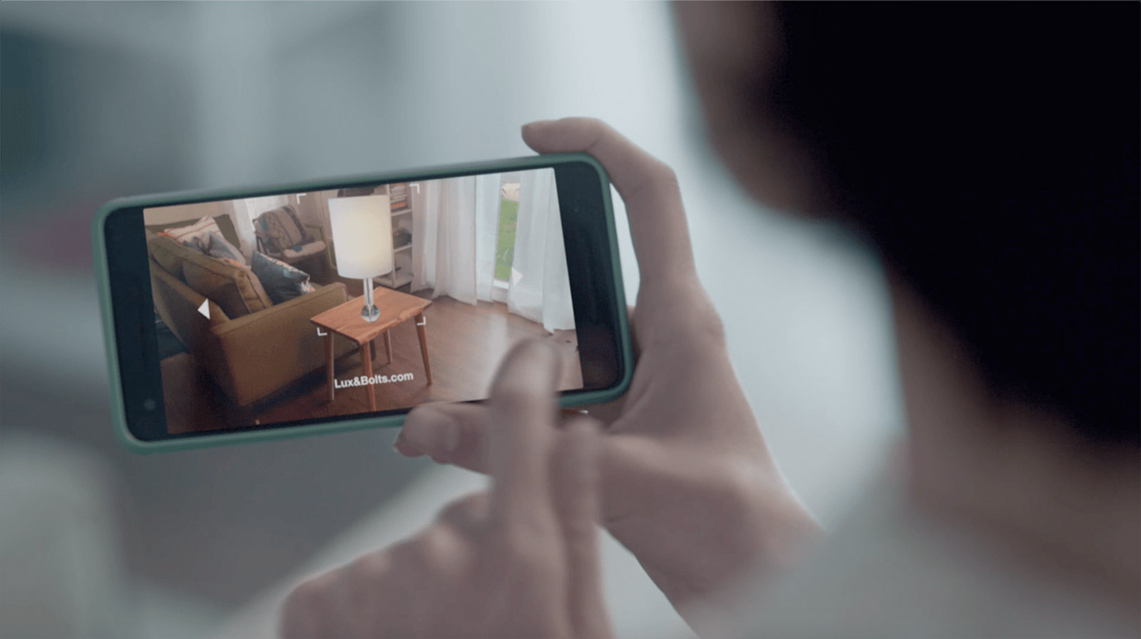 Person using augmented reality on their mobile phone to see how a product would look in their home.